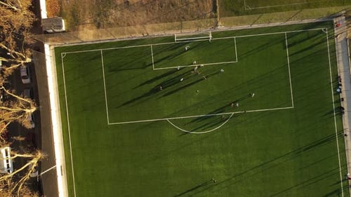 Aerial top down view of football players playing the match at the football ground.