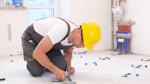 Man Installing Floor Tile in New Construction