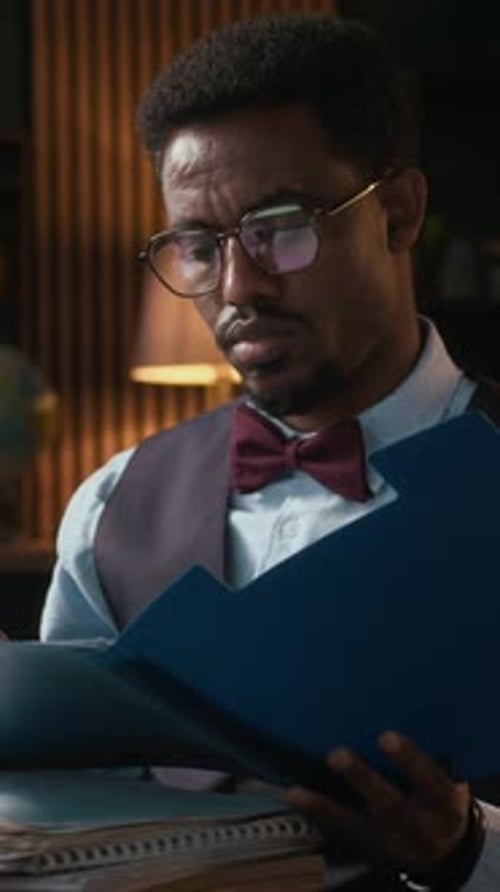Man Reviews Documents at Desk in Office Setting
