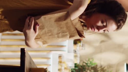 Cliente de tienda de vídeo vertical que utiliza una bolsa de papel descomponible