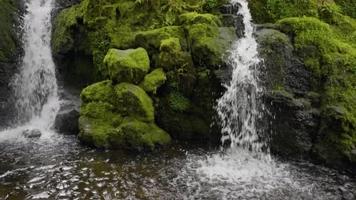 Aufsteigender Blick über einen friedlichen Wasserfall in üppige Wälder