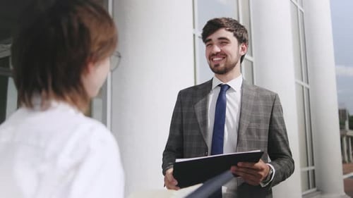 Business Meeting and Document Presentation Outside Office Building