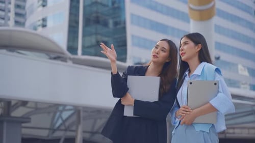 Asian two businesswoman standing with confidence outdoors in the city. Attractive beautiful female e