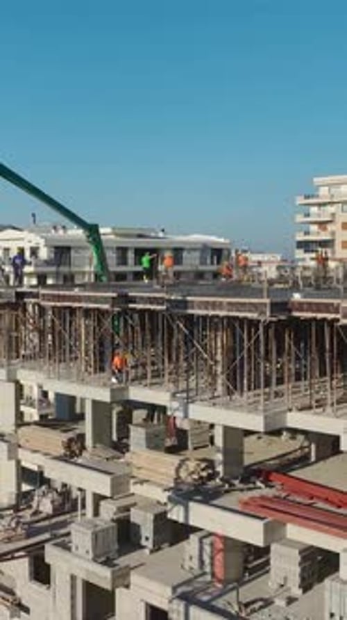 Vertical Video of Residential Construction With Engineers Supervising a Crane Moving Heavy Materials