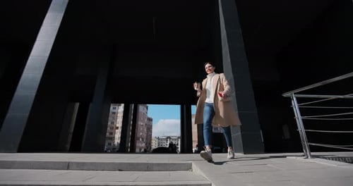Successful Attractive Woman Drinking Take Away Coffee While Running Down Stairs on Street