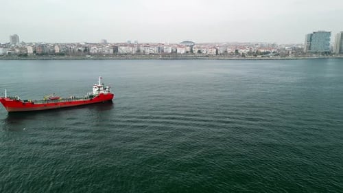 Fly by of a red cargo ship in the sea