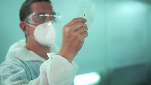 Der kaukasische Mann überprüft die Farbmalerei in der Reparaturmechaniker-Lackiererei