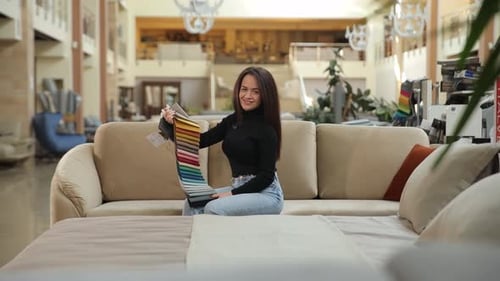 A Woman Picks Fabrics and Pillows at a Furniture Store for Her Living Space