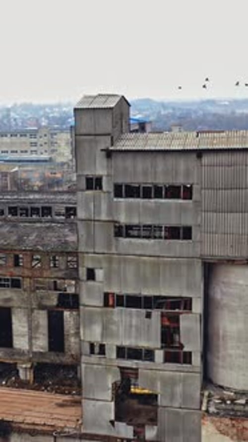 A huge state-owned factory with gray walls and broken glasses in the windows