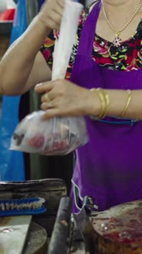 Slow Motion Asian Mature Woman Working in a Fish Shop with Raw Fish on a Round Wood