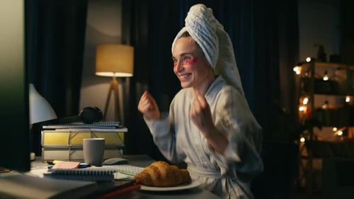 Woman in Bathrobe Using Computer at Night