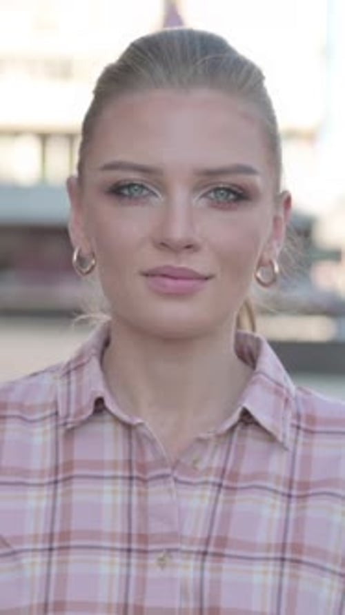 Porträt einer jungen Frau, die im Freien in die Kamera schaut, vertikales Video
