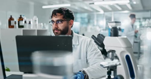 Scientist Working on Laptop in Modern Laboratory