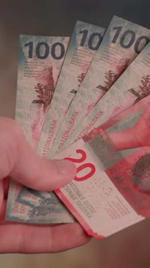 Hand Holding Swiss Francs Bank Notes Close Up