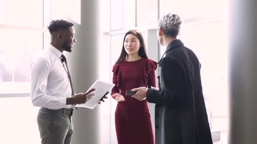 Diverse business team discussing plans in modern office lobby daytime