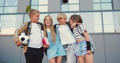 Portrait happy smiling group of high school kids hugging looking at camera. Children girls and boys