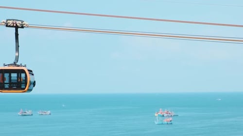 Modern Cable Car Gondola Ride Over Tropical Seaside with Fishing Boats and Turquoise Sea on Phu Quoc