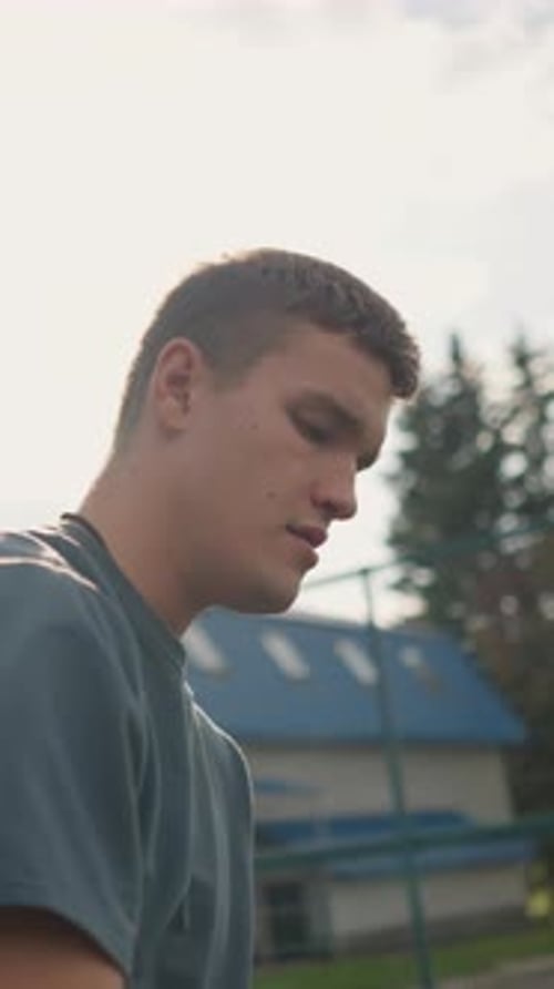 Young Man with Volleyball Standing Outside in Sunlight