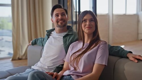 Happy Couple Relaxing Together on Sofa at Home