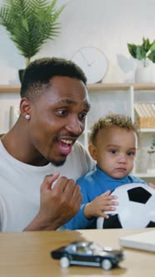 Excited Man and Infant Holding Ball