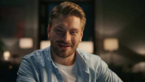 Man Smiling at Home in Low Lighting