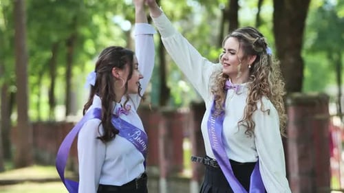 Dos estudiantes de último año que se gradúan bailando el último día de clases