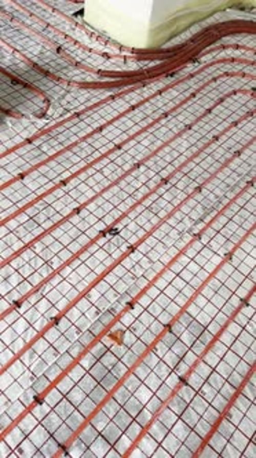 Installation of underfloor heating system indoors. Camera moving right and up