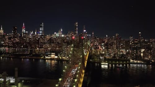 Illuminated Skyscrapers in Midtown Manhattan Rise Against the Night Sky While Cars Coming From