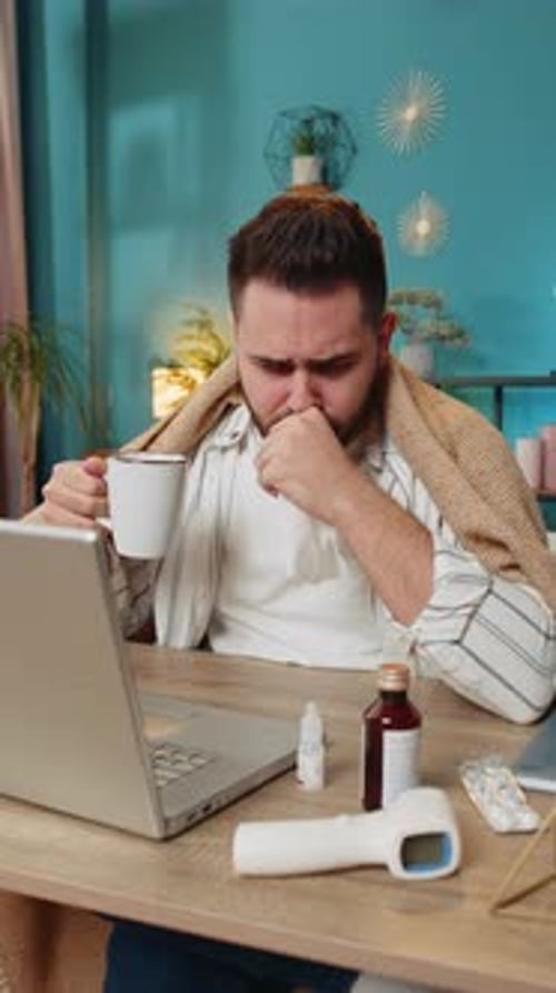 Sick Ill Young Businessman Suffering From Cold Flu or Allergy Wipes Snot Working on Laptop at Office