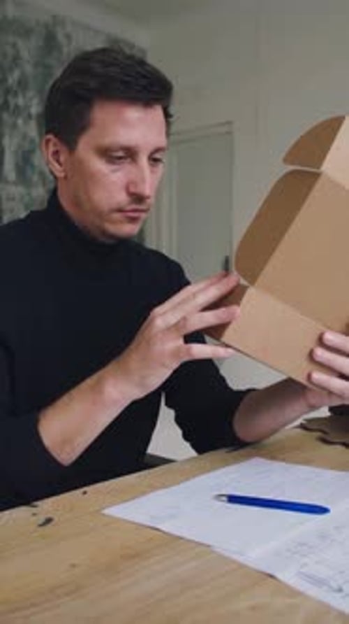 A Designer Designs a Cardboard Package a Man Collects Data From a Cardboard Package and Comes Up