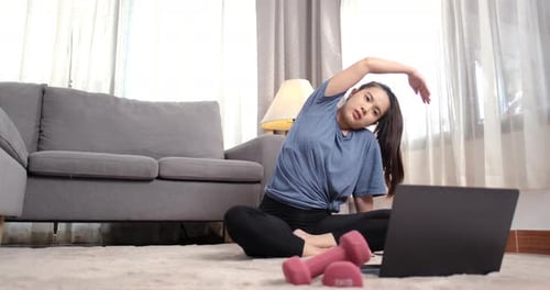 Woman Doing Stretching Exercises on Floor at Home