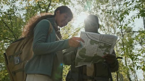 Two Hikers Reading Map in the Forest
