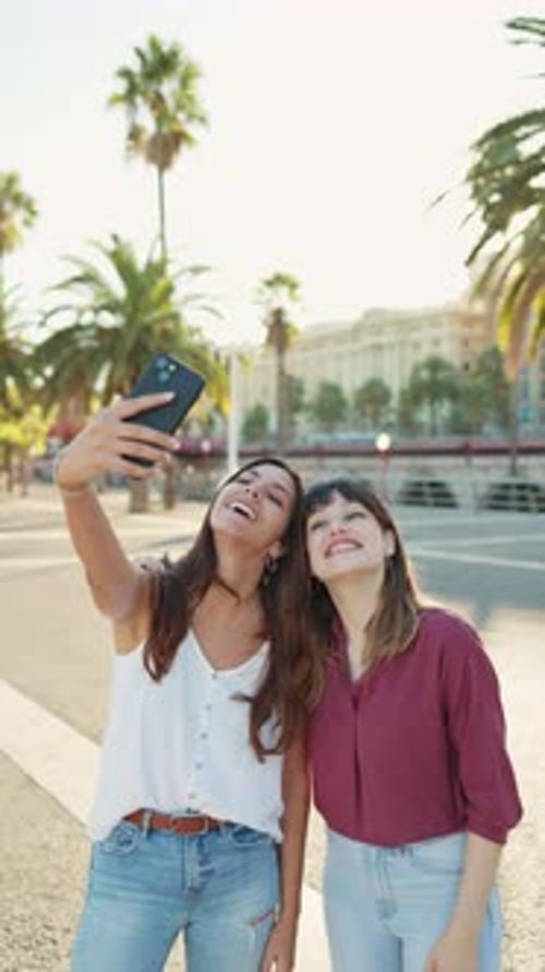 Two Friends Take Selfie in Sunny Urban Location