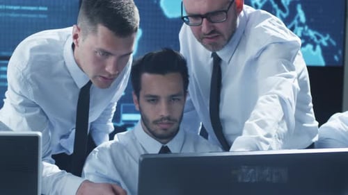Team-IT-Sicherheitsexperte arbeitet in einem hellen Überwachungsraum voller Displays