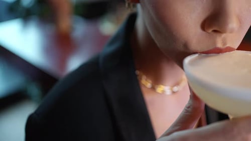4K Close up of Caucasian woman drinking cocktail at luxury bar.