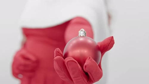 Elegant Woman Offers Christmas Bauble Decoration