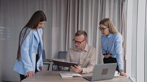 Project colleagues planning together. Group of young business managers working in modern office.