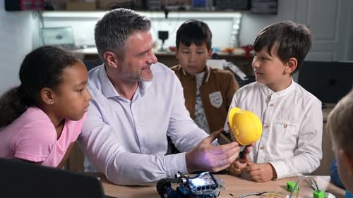 Teacher Explains Robotics to Eager Elementary Students