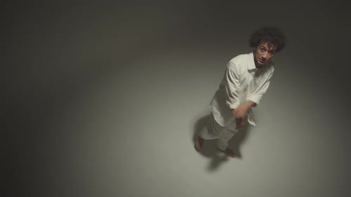 Man Dancing Expressively in White, Bird's Eye View