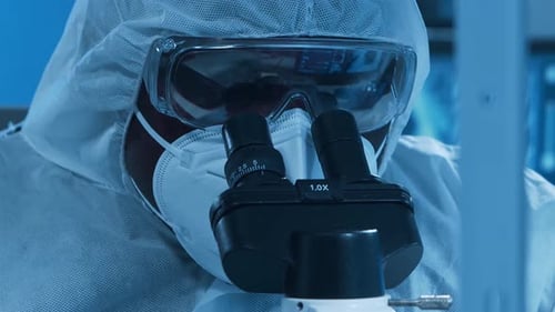 Scientist Works with Microscope and Test Tube