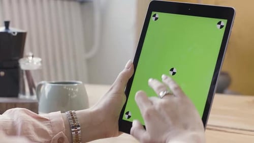 Woman Using Tablet with Green Screen in Office