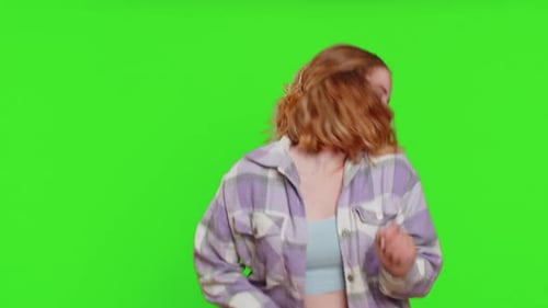Une femme heureuse s'amuse à danser en se déplaçant au rythme en tamponnant en levant les mains en faisant un geste de danse dub