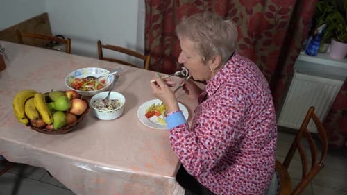 Mature Woman Eating Lunch at Dining Table