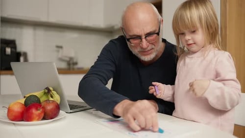 Großvater bringt Enkelin zu Hause Zeichnen und Hausaufgaben bei