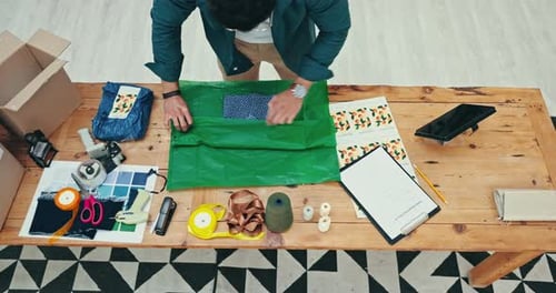 Hands, delivery and fashion designer person wrapping a product in office for courier shipping