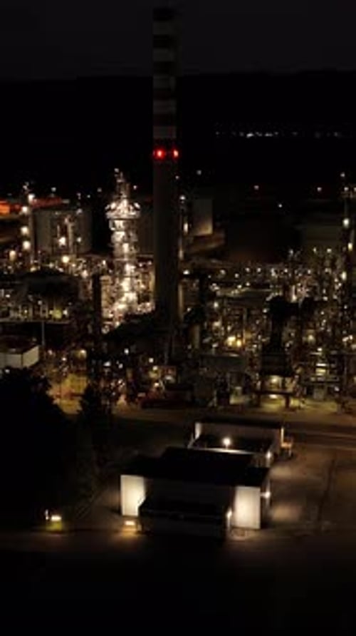 The Beautifully Illuminated Industrial Complex at Night Shines in the Dark Sky Above