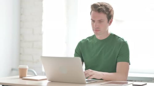 Young Adult Stressed While Working on Laptop