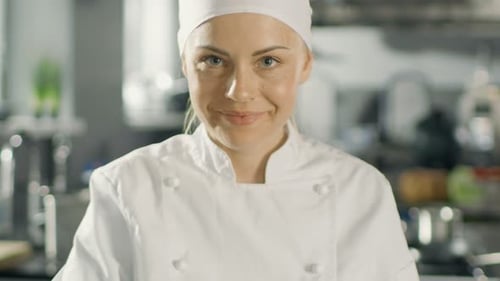 Portrait of a Young Woman Chef Smiling While Cooking in a Modern Kitchen.