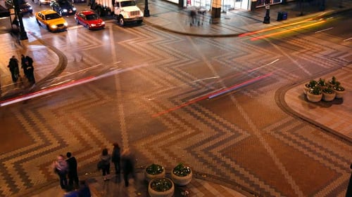 Night time lapse captures urban traffic streaks speeding through city intersection