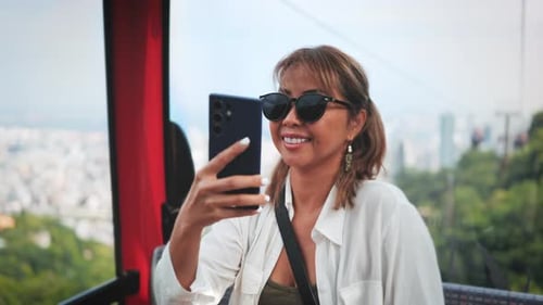 Woman Enjoys Cable Car Ride Above City